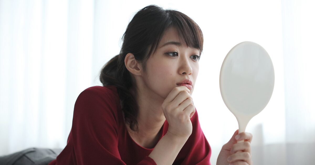 30代でシミ(しみ)や目尻や口元、おでこ、額、目の下のシワ(しわ)、ほうれい線が気になり始めた女性のイメージ画像。化粧水や乳液、クリームなどの基礎化粧品に加えて美白美容液、シワ改善美容液を取り入れたいが何を使ったら良いかわからなくて悩んでいる。